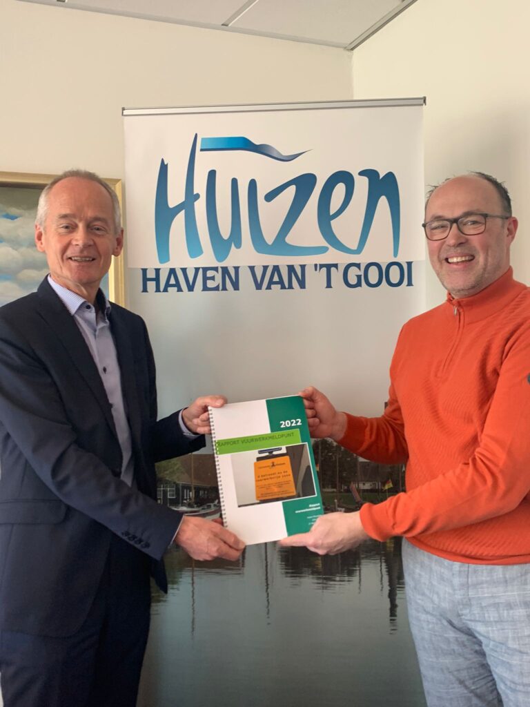 Ruben Woudsma overhandigd op deze foto het vuurwerkrapport aan burgemeester Niek Meijer van Huizen.