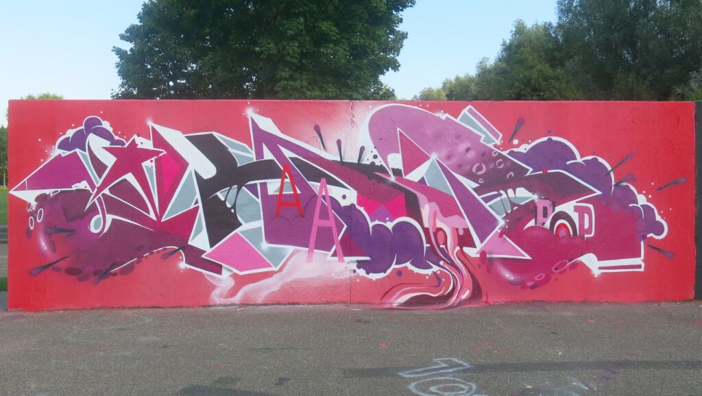 Kunstwerk op graffitimuur uit 2015 met tekst en rood als basiskleur